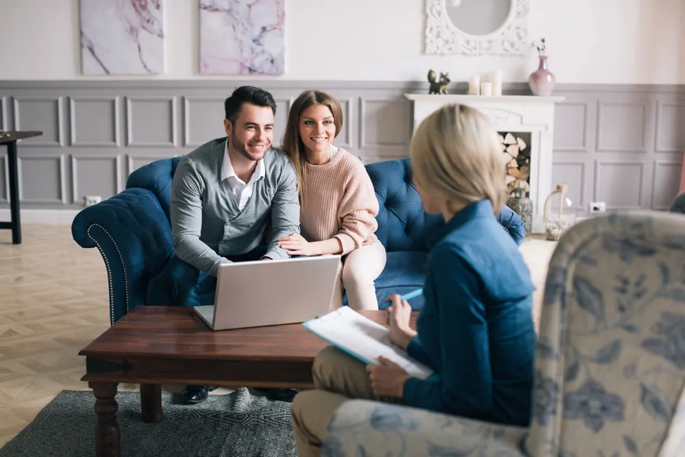 Happy clients meeting with Design First Builders design consultant for home renovation planning and design consultation in elegant living room setting in Chicago