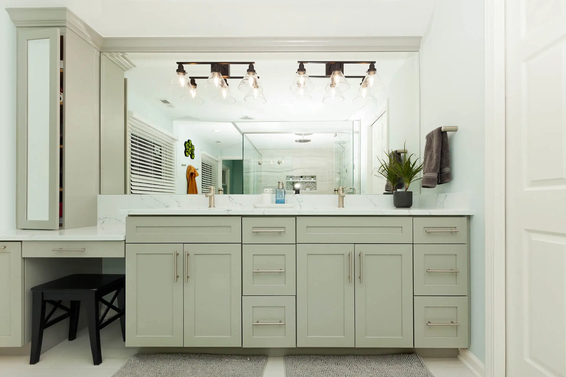 Design First Builders Naperville custom bathroom vanity with makeup seating area, quartz countertops, industrial light fixtures, and large mirror