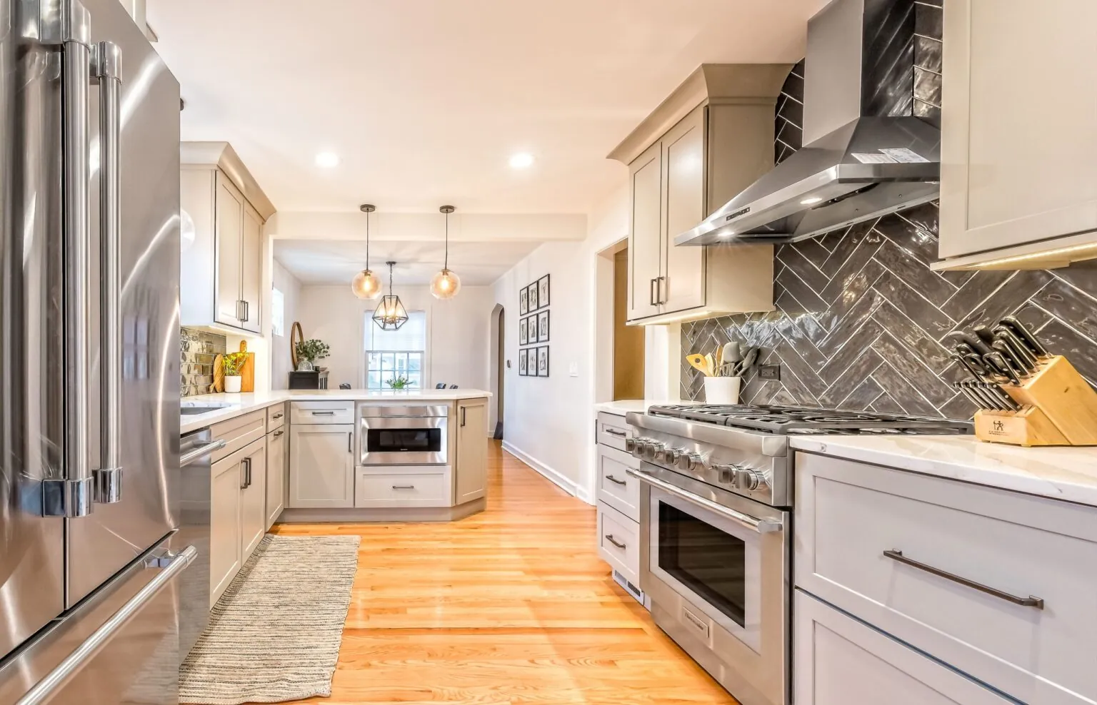 Design First Builders Park Ridge kitchen with floating wood shelves, stainless steel appliances, beige shaker cabinets, and subway tile backsplash