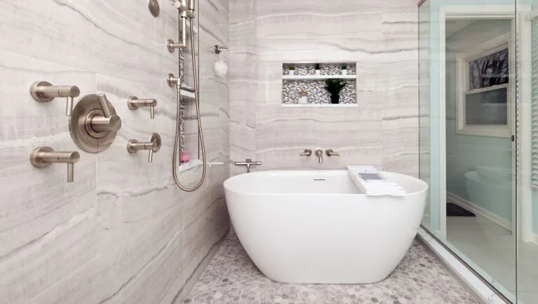 Design First Builders Naperville luxury spa bathroom with freestanding soaking tub, multiple body spray shower system, marble walls, and mosaic tile niche