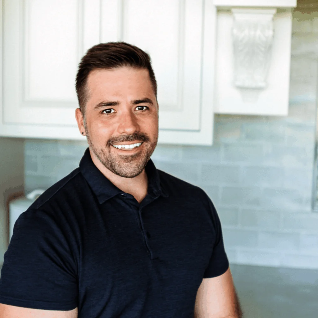 Adam DeLay, Senior Architectural Designer and Plans Specialist at Design First Builders, professional headshot in white kitchen setting in Chicago