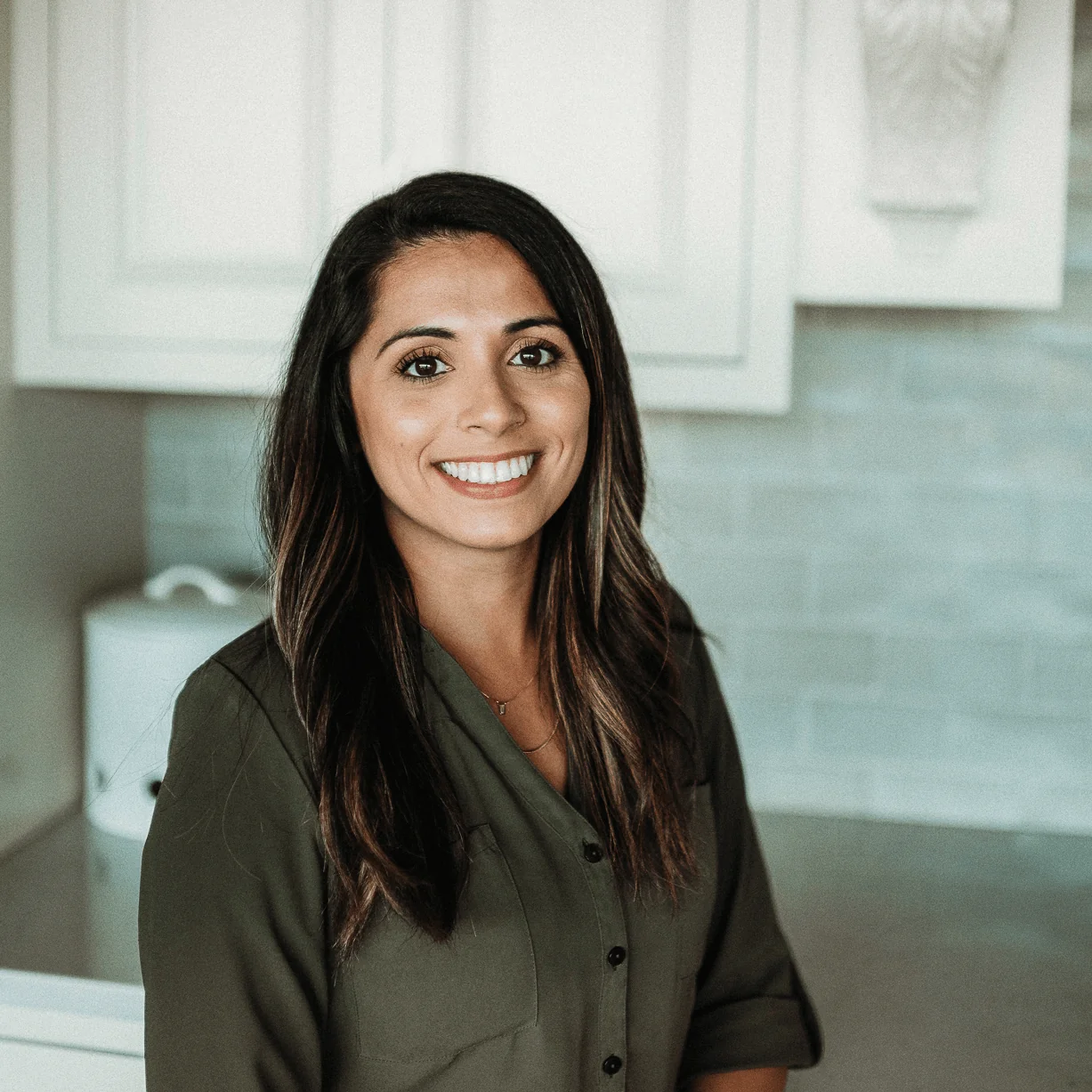 Aja Gutzman, Purchasing Manager at Design First Builders, professional headshot in white kitchen setting in Chicago