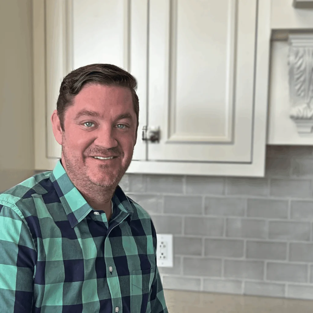 Brian O'Neil, Director of Development at Design First Builders, professional headshot in white kitchen setting in Chicago