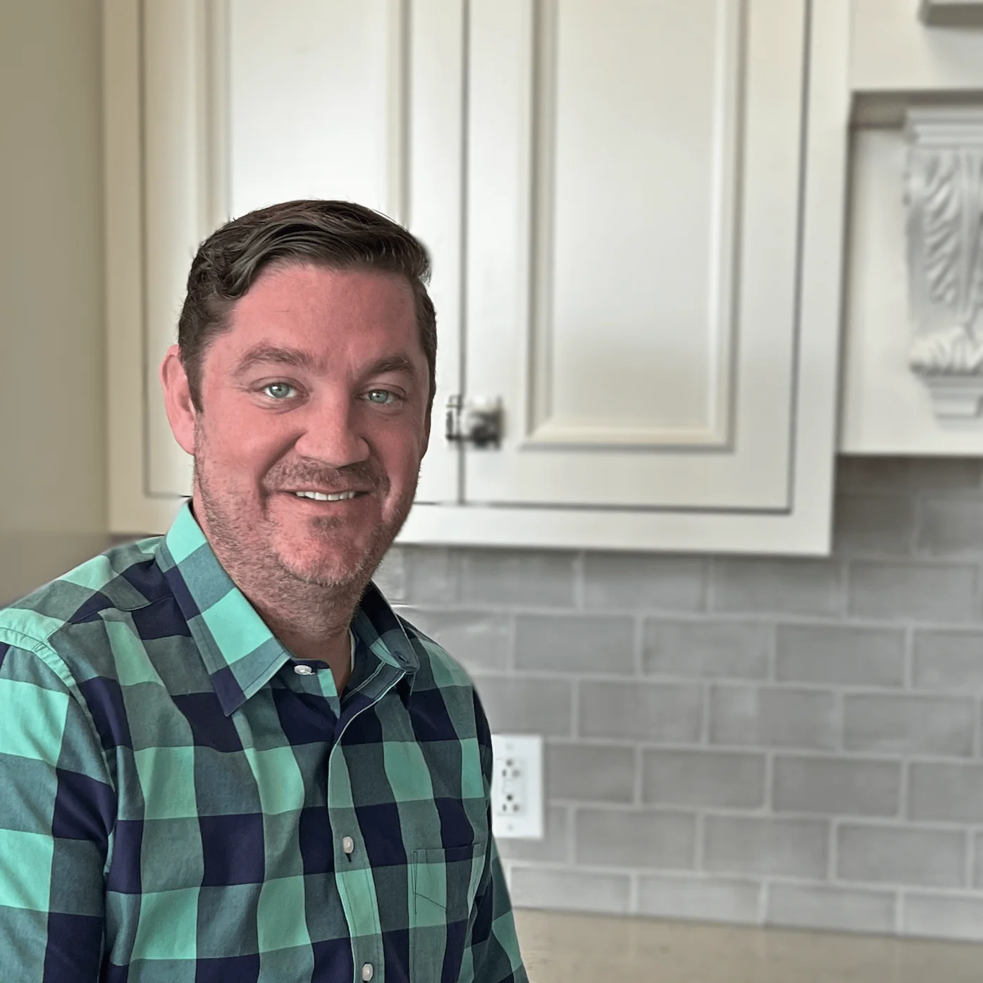 Brian O'Neil, Director of Development at Design First Builders, professional headshot in white kitchen setting in Chicago