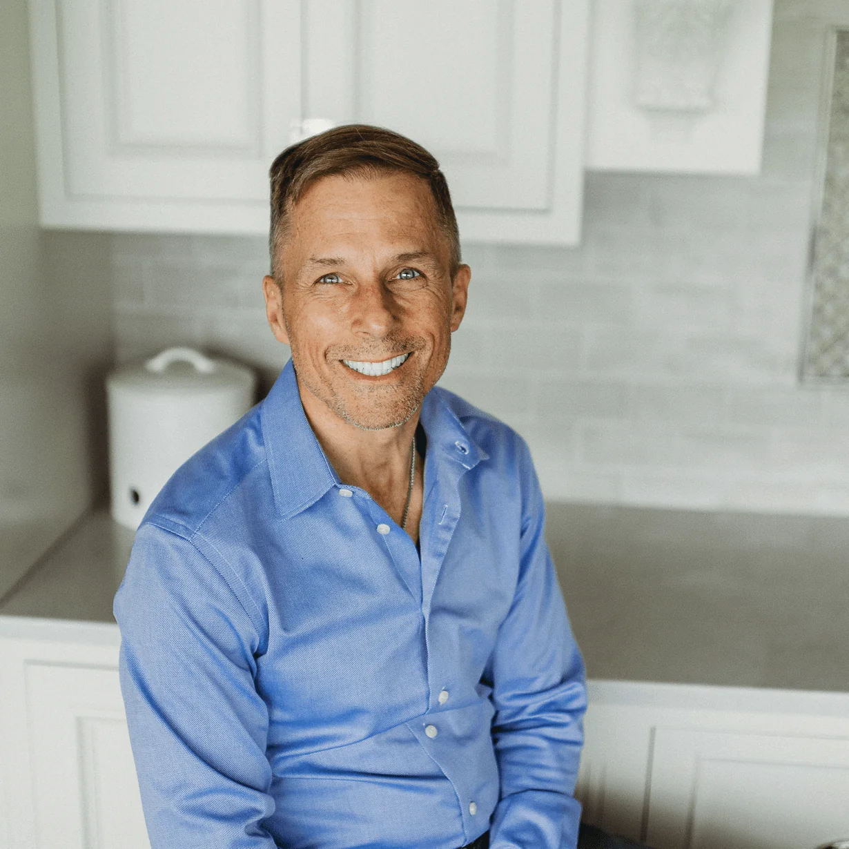 Dan Schoendorff, Vice President at Design First Builders, professional headshot in white kitchen setting in Chicago