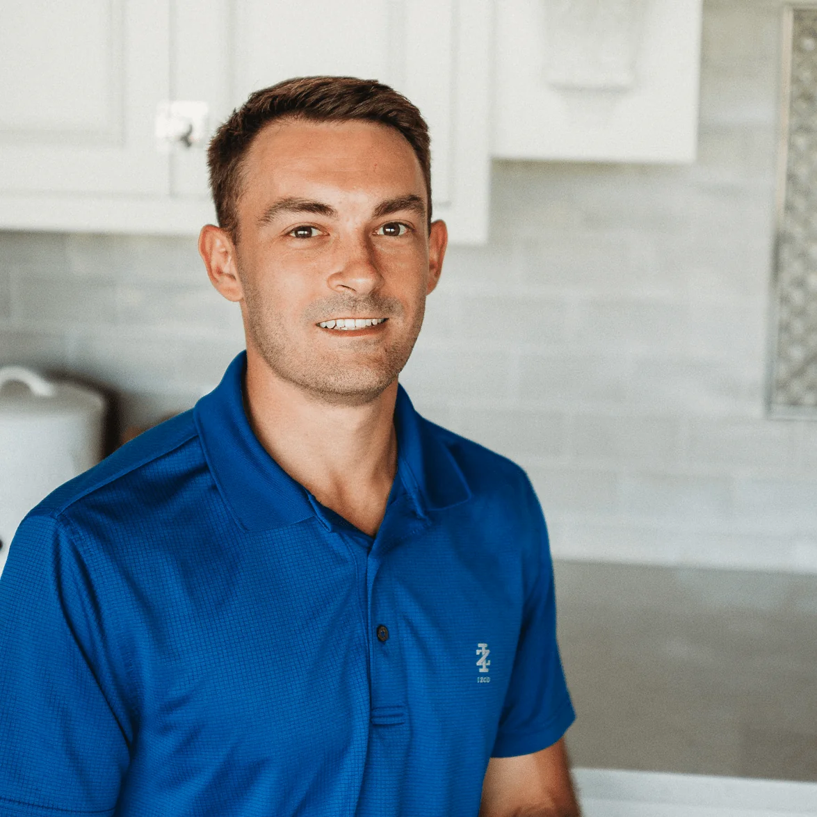 Jack Phelus, Controller at Design First Builders, professional headshot in white kitchen setting in Chicago