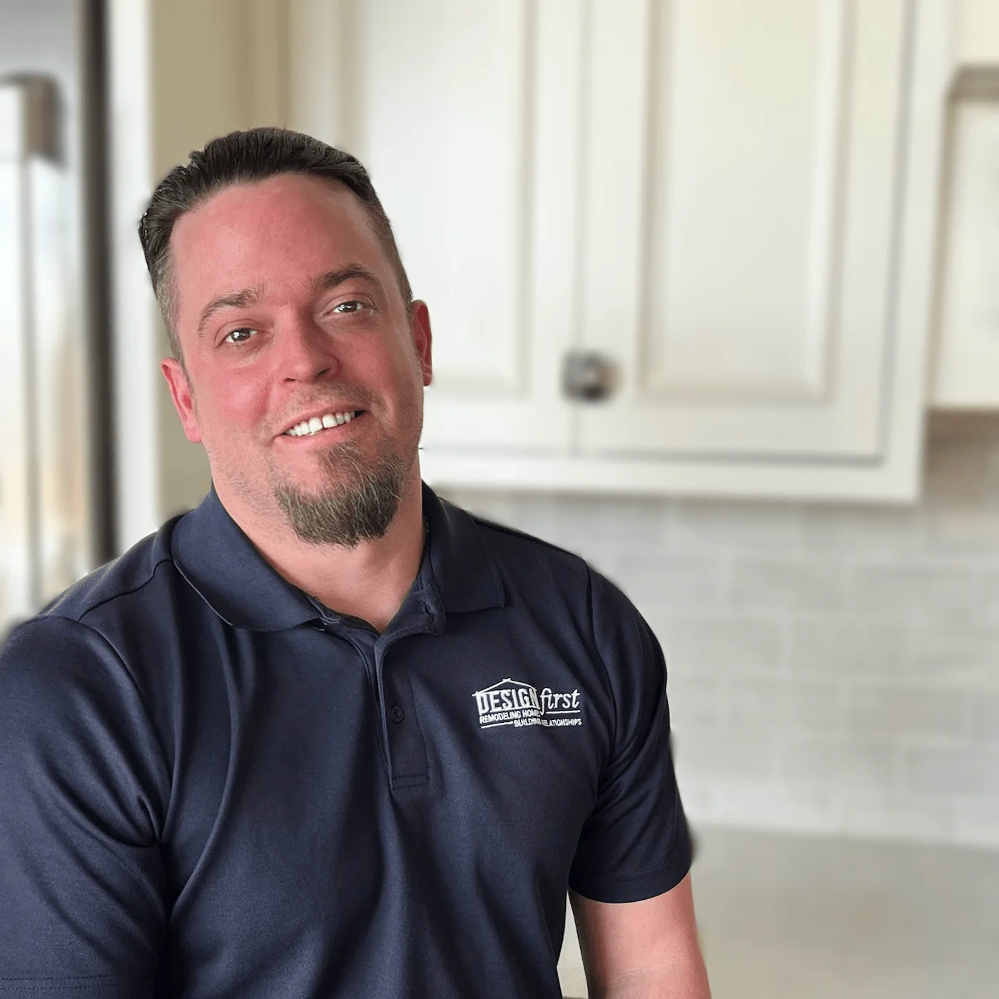 Matt Smillie, Project Manager at Design First Builders, professional headshot wearing company polo in white kitchen setting in Chicago