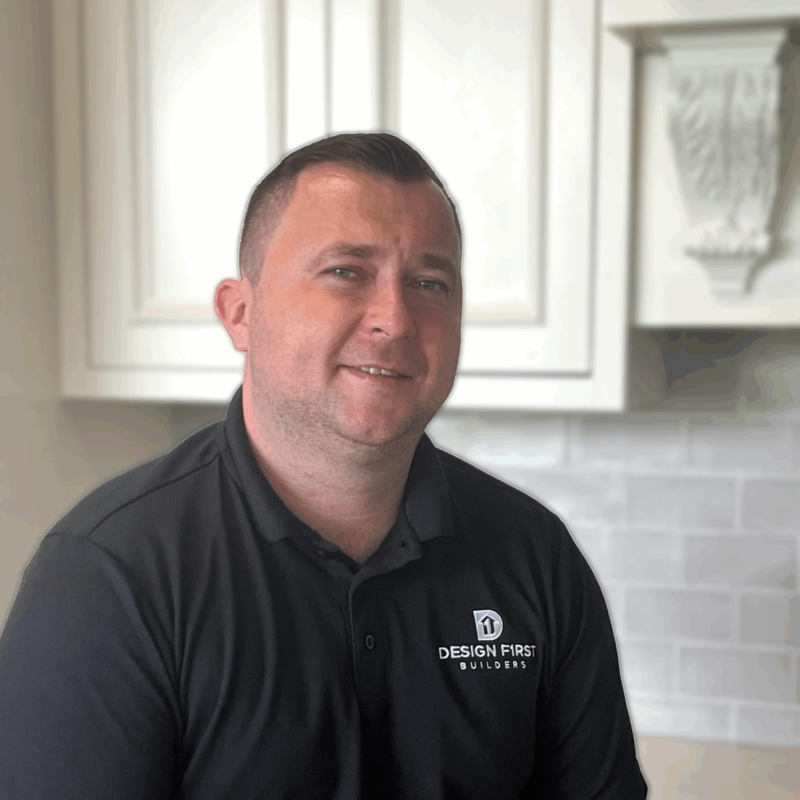 Peter Figiel, Project Manager at Design First Builders, professional headshot wearing company polo in white kitchen setting in Chicago