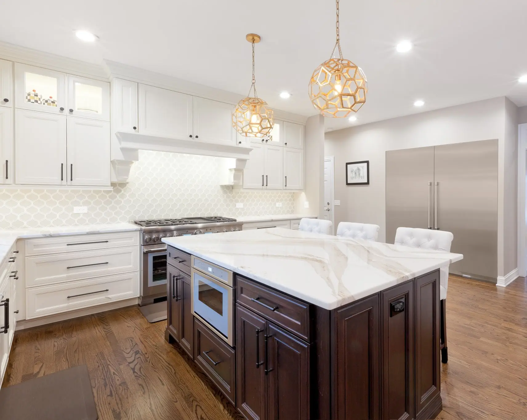 Elegant kitchen remodel with white upper cabinets, dark wood island, and quartz countertops by Design First Builders
