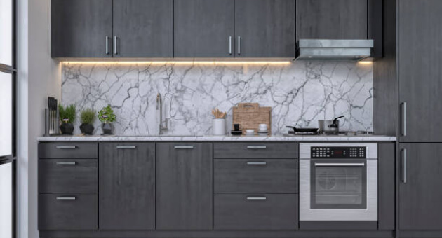 Kitchen with gray colored cabinets and marble walls