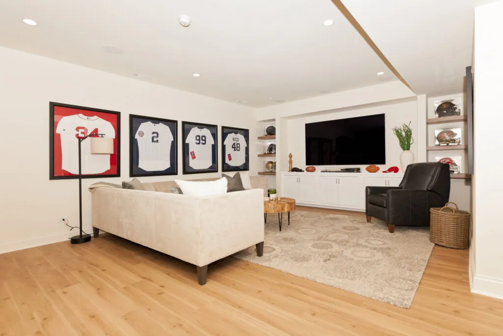 Luxury finished basement remodel in Chicagoland home featuring entertainment area with custom built-ins, recessed lighting, and comfortable seating for guests