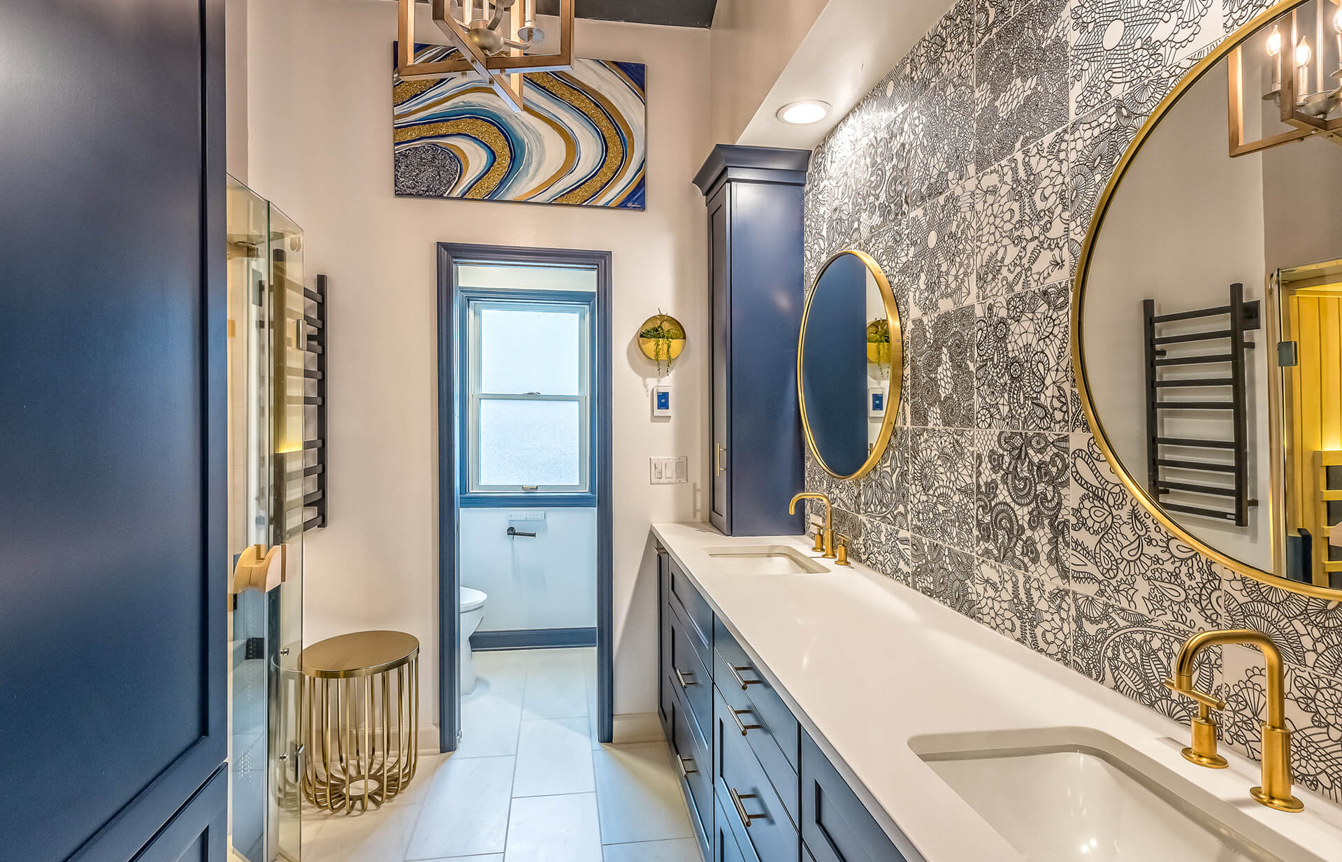 Luxury bathroom renovation by Design First Builders featuring navy blue vanity, gold fixtures, statement wallpaper, dual sinks, and contemporary design in Park Ridge, Illinois