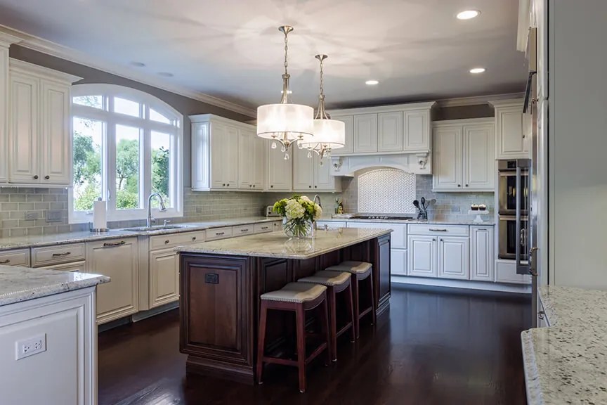 Luxury white kitchen remodel with dark island and pendant lights in Chicago’s western suburbs
